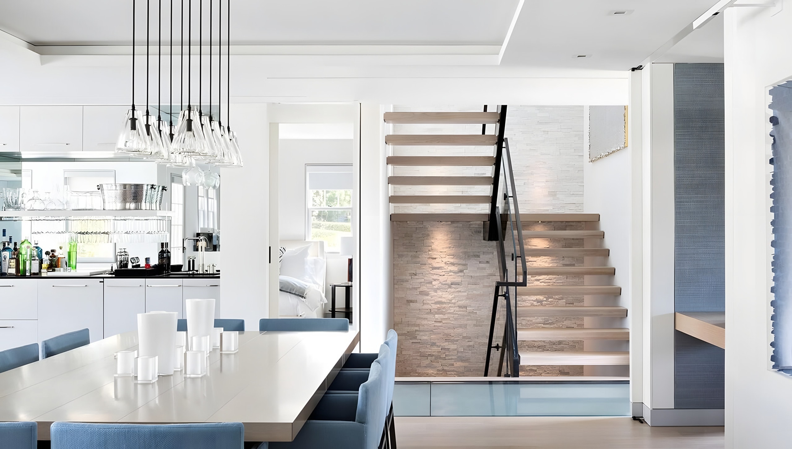 Dining room, bar, and floating staircase connected in one open floor plan