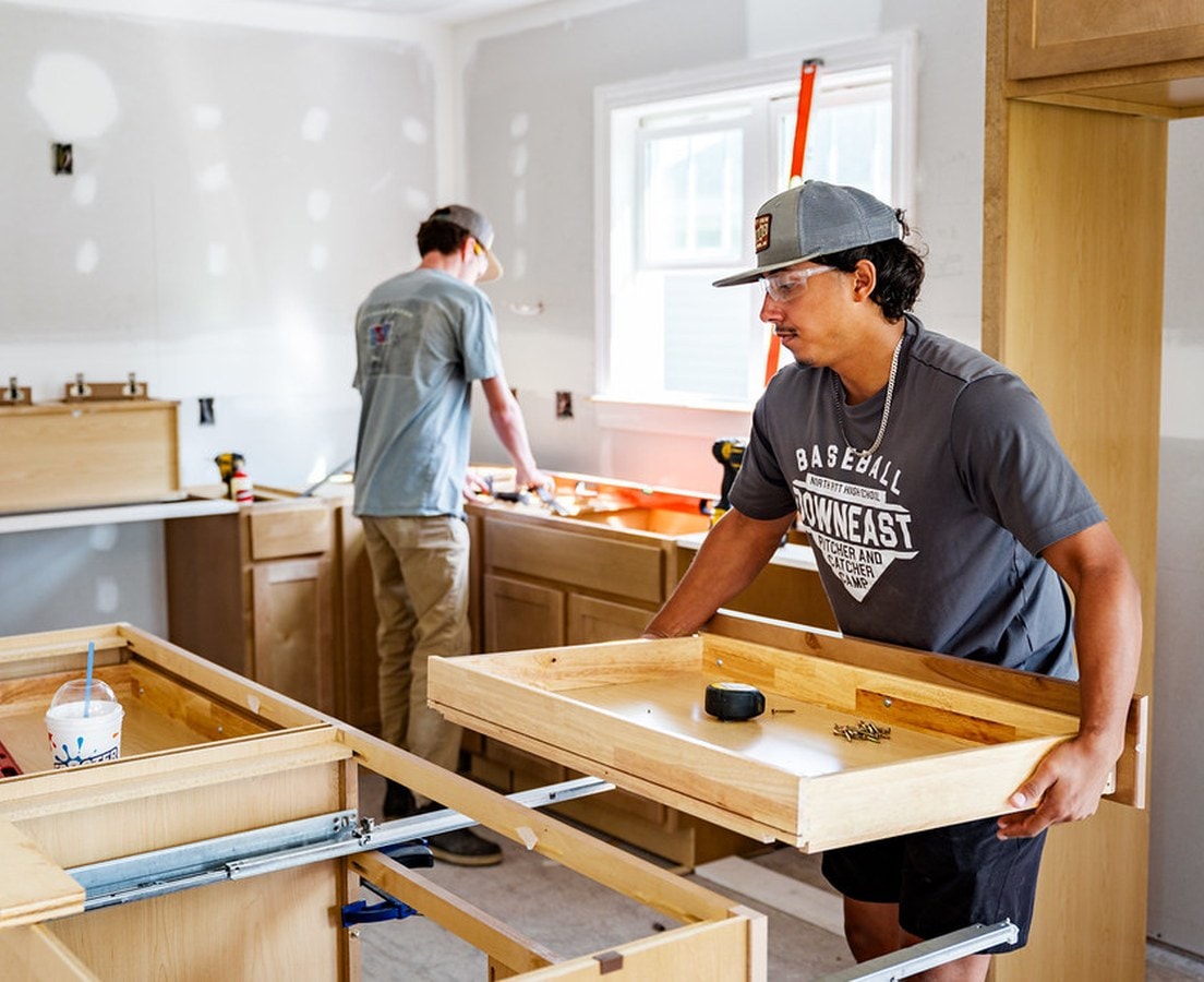 Installers fitting new cabinet boxes during a kitchen remodel