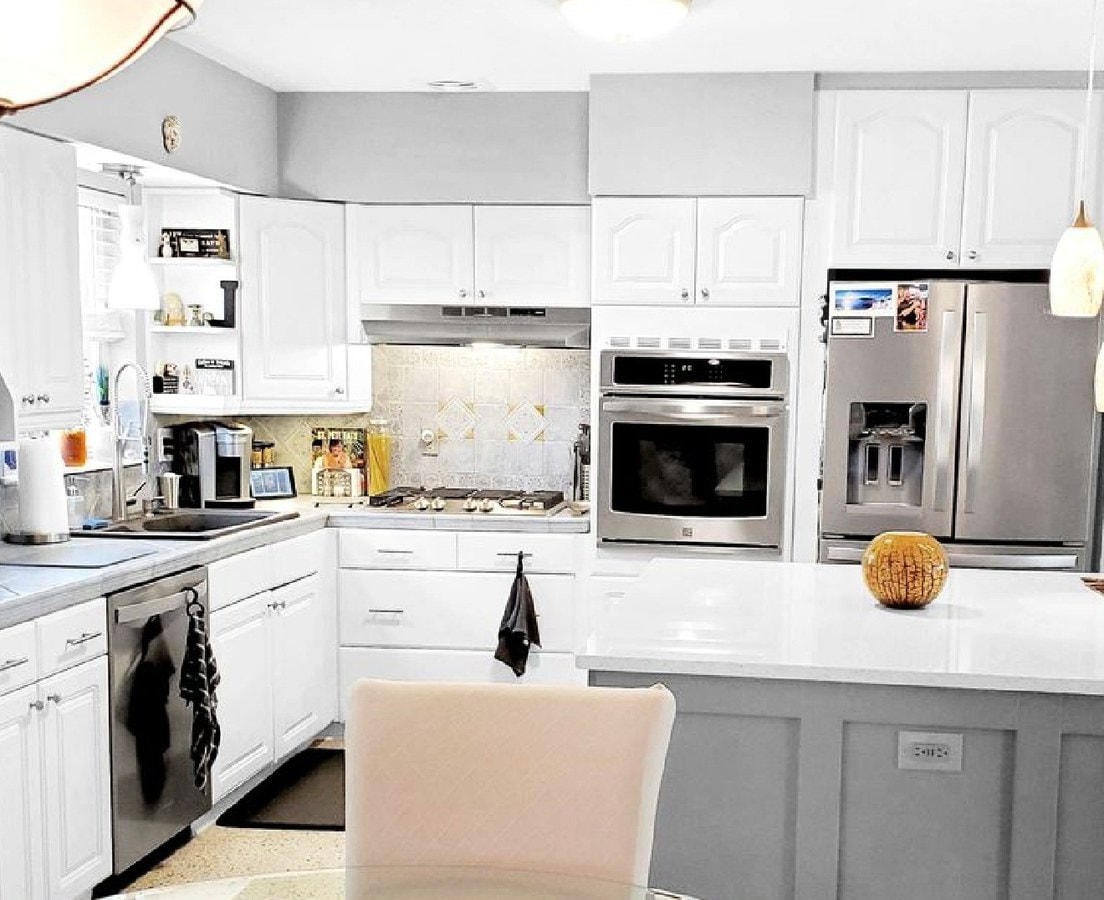 Finished white kitchen with stainless appliances and a gray island