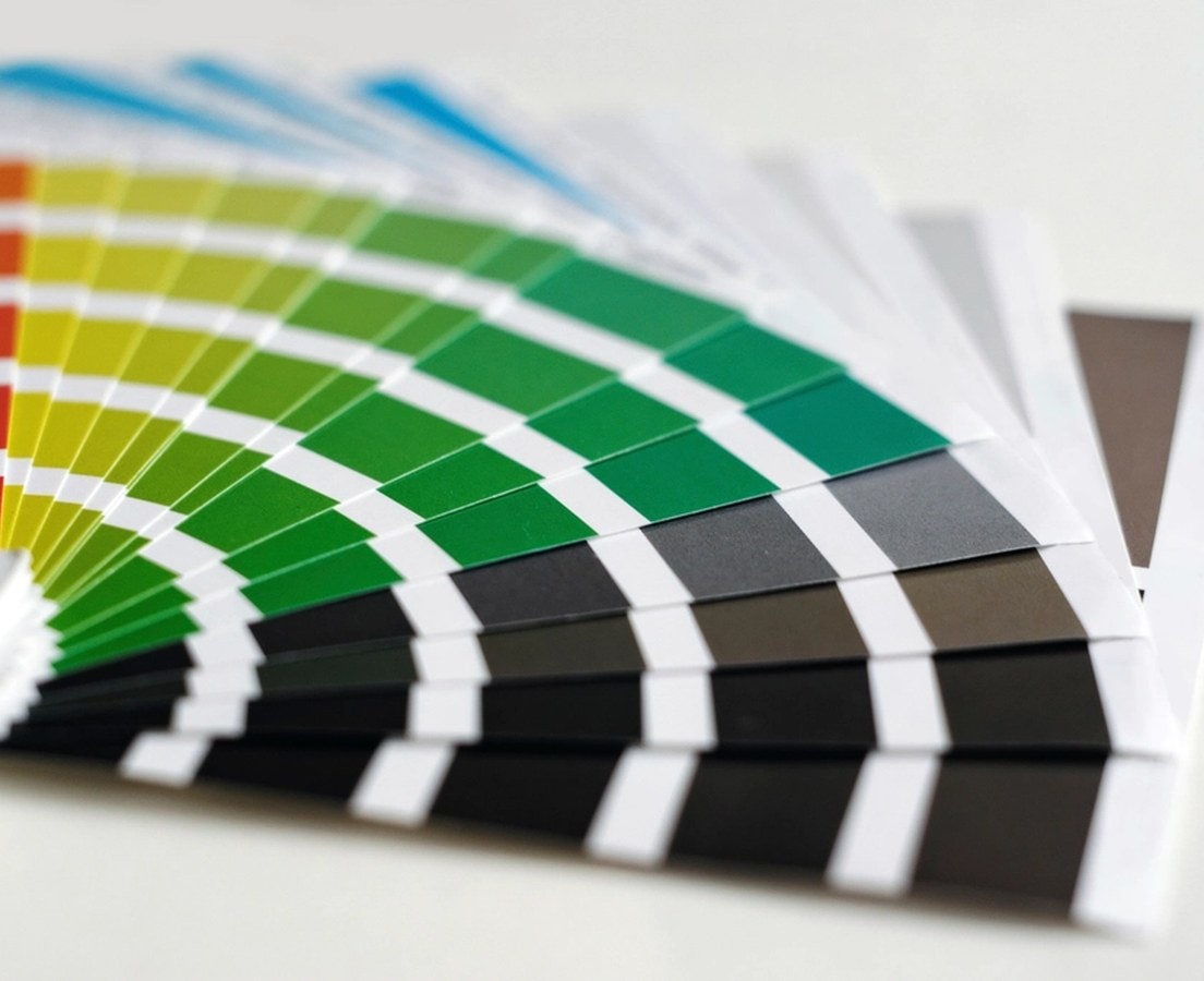 Fanned-out paint color sample cards in reds, greens, and grays