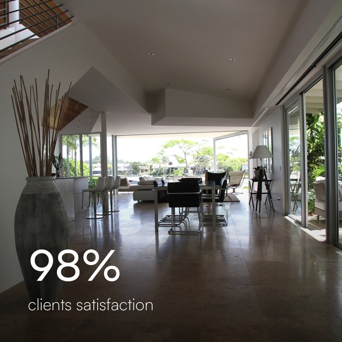 Open-plan living and dining room with polished stone floors and floor-to-ceiling sliding doors, 98% client satisfaction