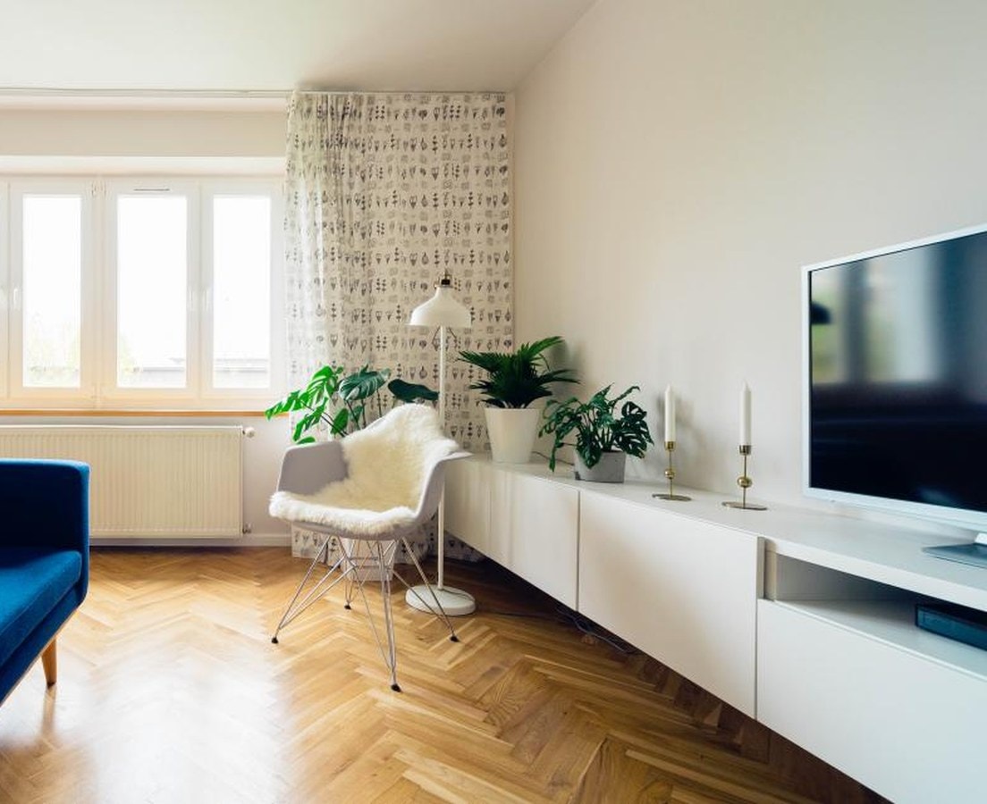 Bright living room with a flat-screen TV above a long white media console