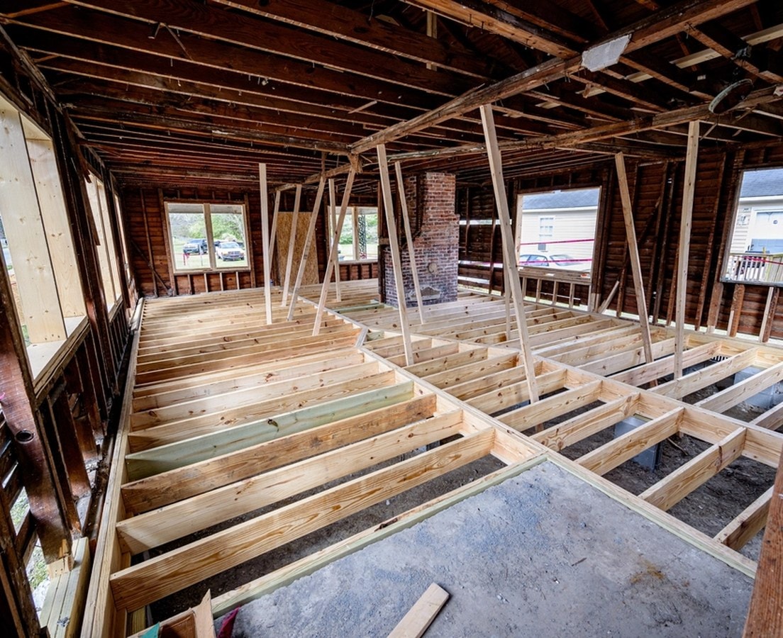 Temporary posts shoring up ceiling joists over a new floor frame