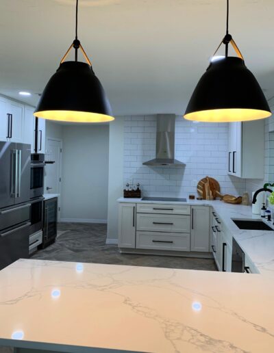 Kitchen remodeled with white cabinets and white marble granite countertop by Ethicore